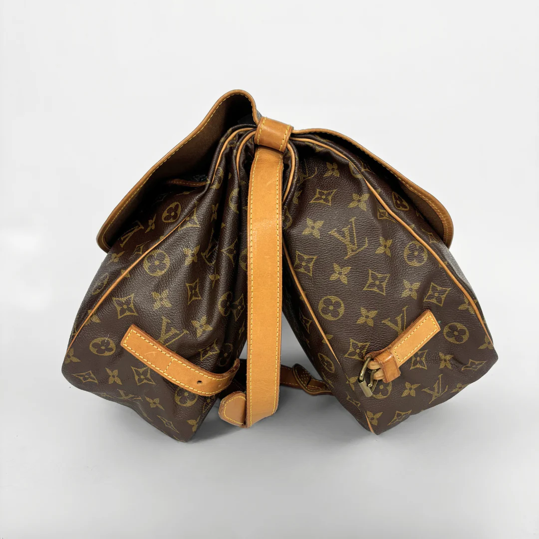 Brown monogrammed bag with tan leather accents on a light gray background