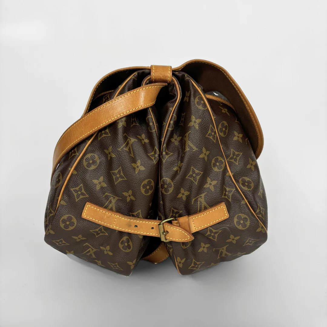 Brown monogrammed bag with tan leather accents on a light gray background