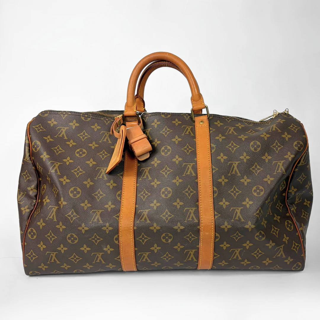 Brown hand bag with orange accents and a prominent logo pattern on a white background