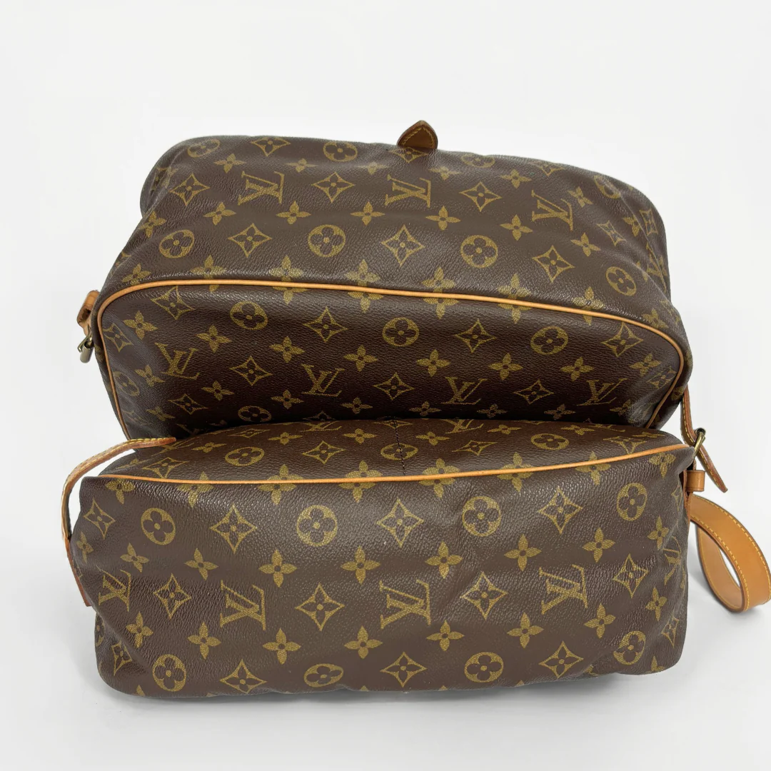 Brown monogrammed bag with tan leather accents on a light gray background