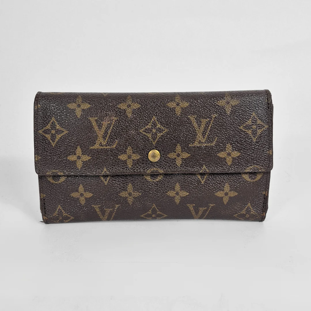 Louis Vuitton wallet with monogram pattern on a light gray background