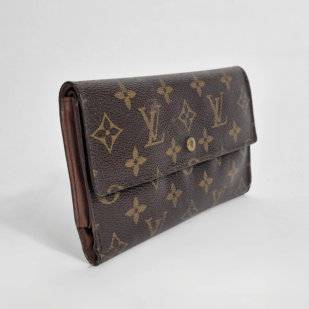 Louis Vuitton wallet with monogram pattern on a light gray background