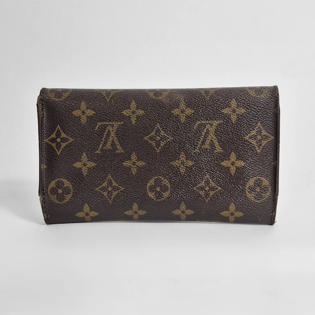 Brown wallet with monogram pattern on a light gray background