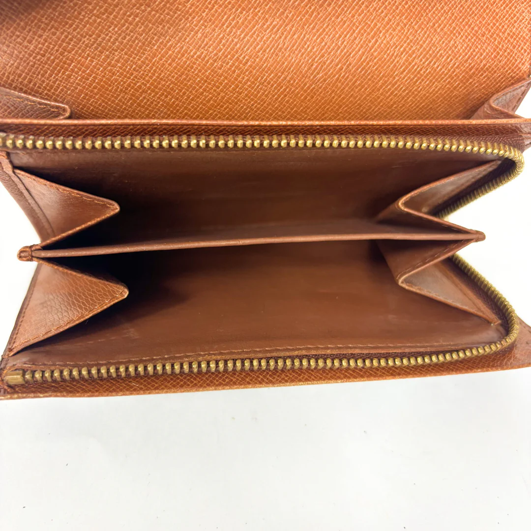 Brown leather wallet with gold zipper on a white background