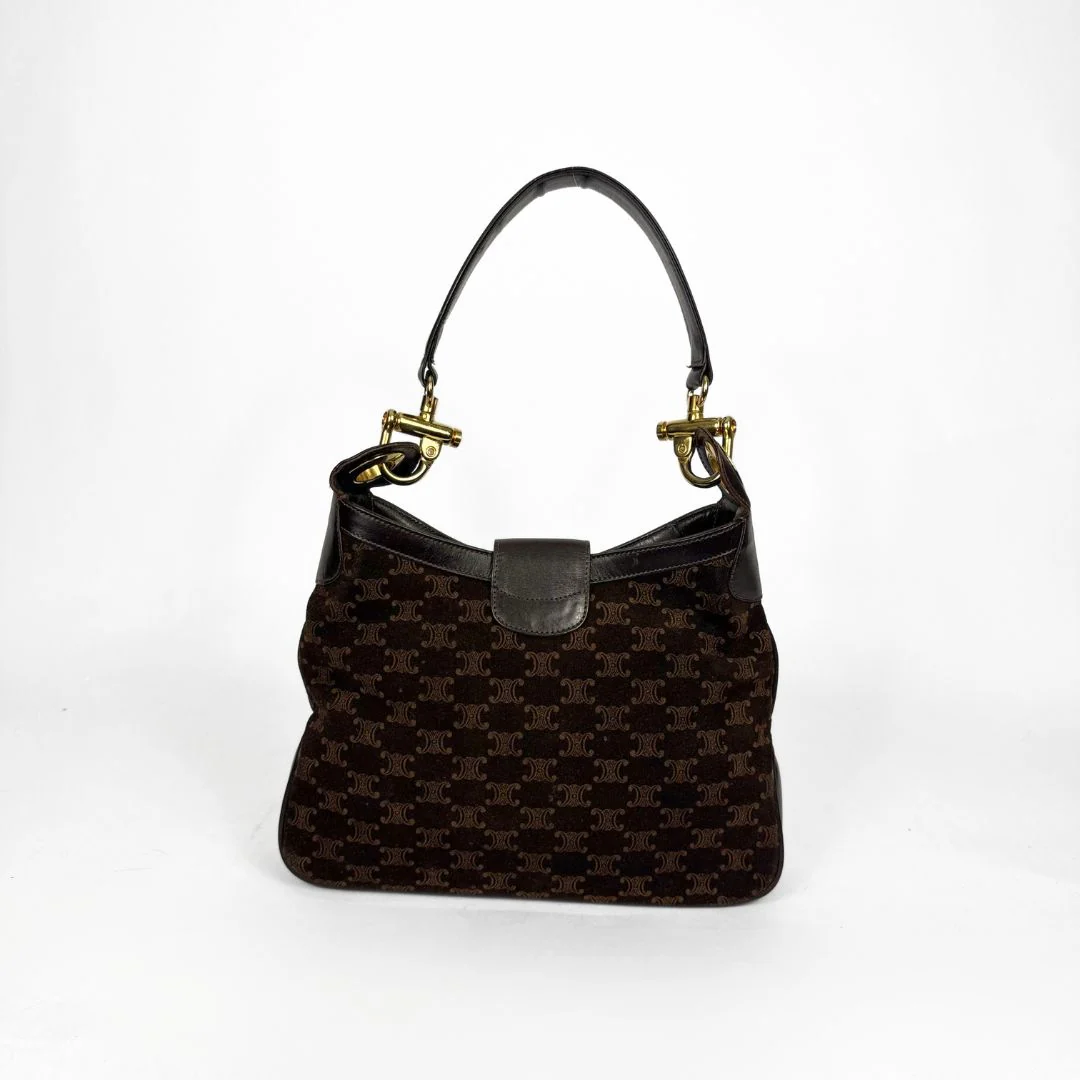 Brown patterned handbag with gold hardware on a white background