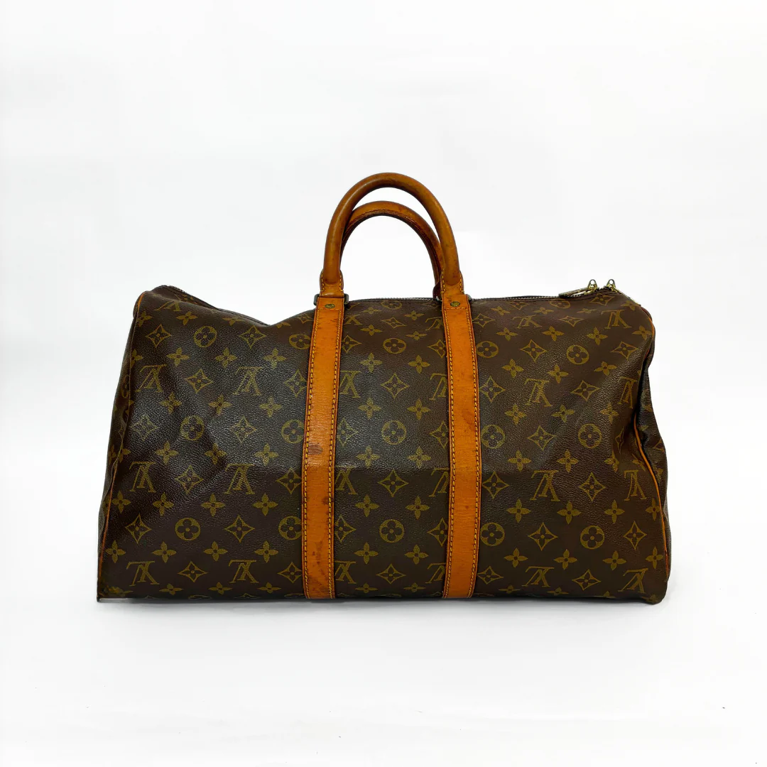Brown travel bag with tan handles and trim on a white background