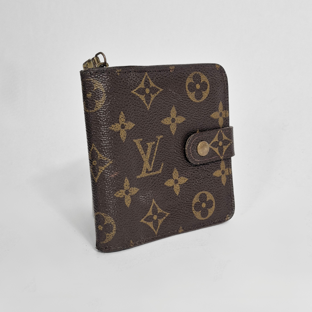 Brown wallet with gold monogram pattern on a light gray background