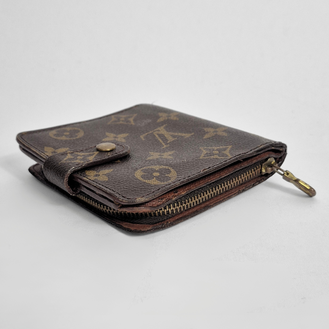 Brown wallet with gold monogram pattern on a light gray background