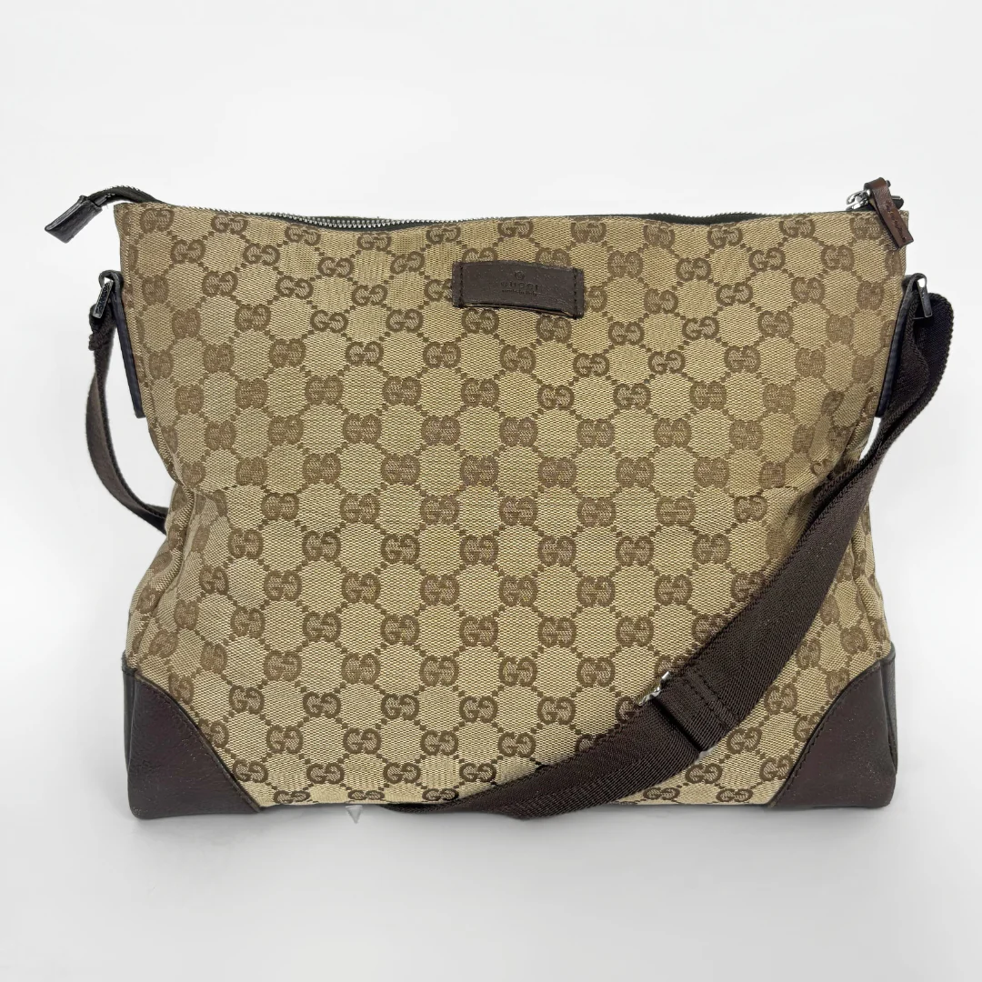 Beige shoulderbag with brown accents and a pattern on a white background