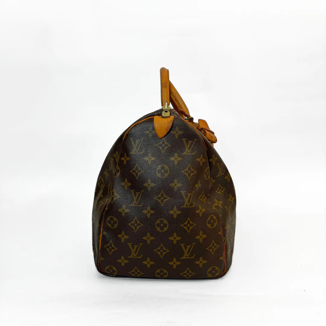 Brown handbag with monogram pattern on a white background