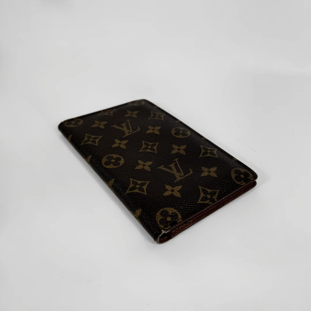 A Louis Vuitton monogram canvas card holder or wallet in dark brown with tan monogram motifs, shown on a plain white background.