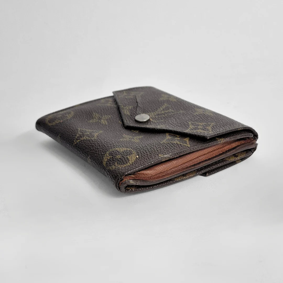 Louis Vuitton wallet with monogram pattern on a white background
