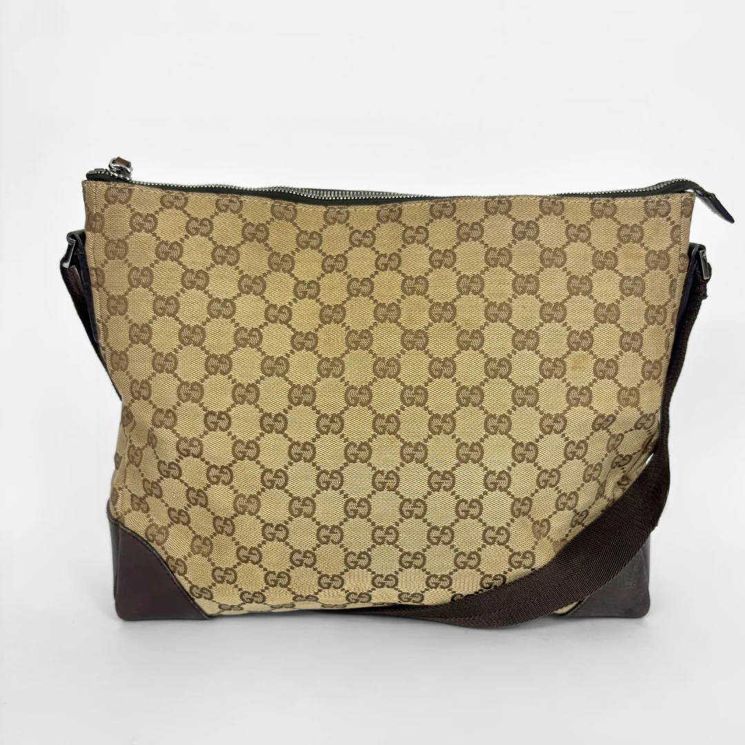Beige shoulderbag with brown accents and a pattern on a white background