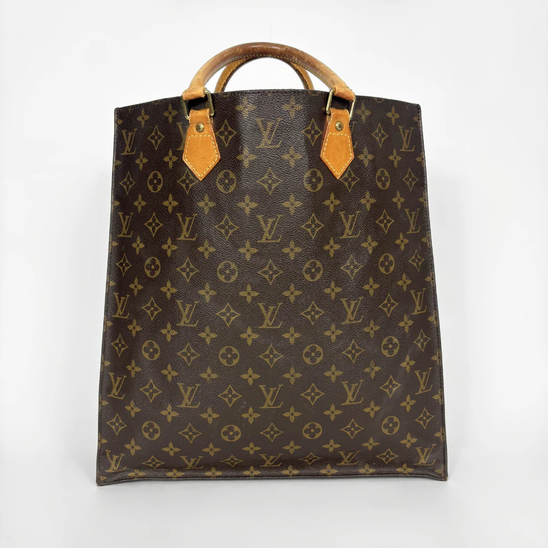 Brown leather bag with monogram pattern on a white background