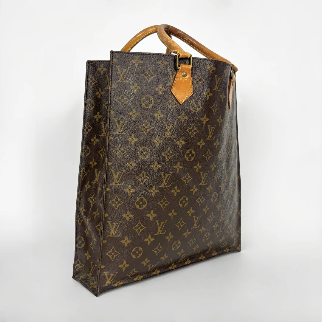 Brown leather bag with monogram pattern on a white background