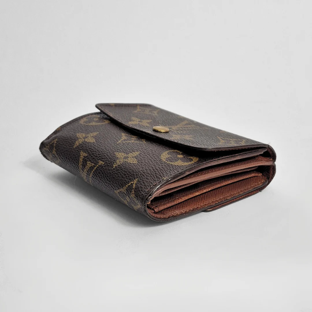 Folded brown wallet with monogram pattern on a light gray background