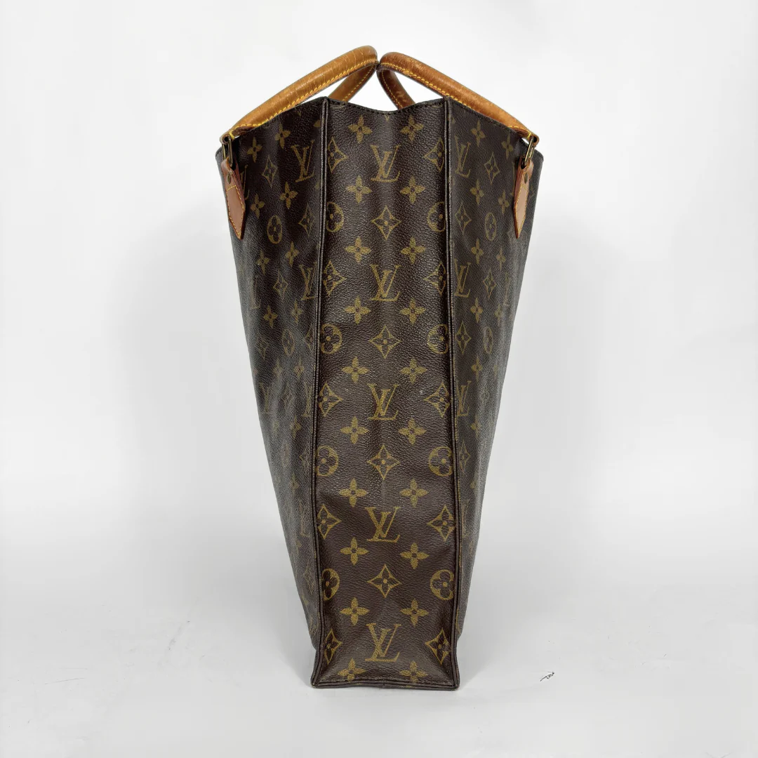Brown leather bag with monogram pattern on a white background