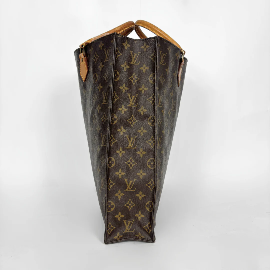 Brown leather bag with monogram pattern on a white background