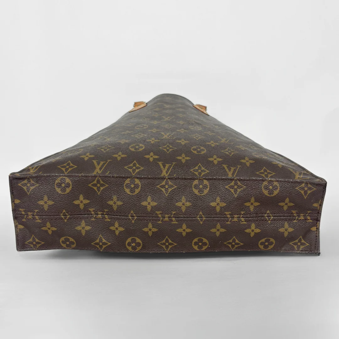 Brown leather bag with monogram pattern on a white background