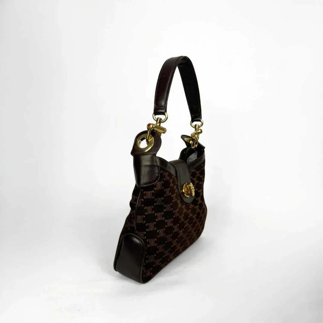 Designer handbag with gold hardware on a white background