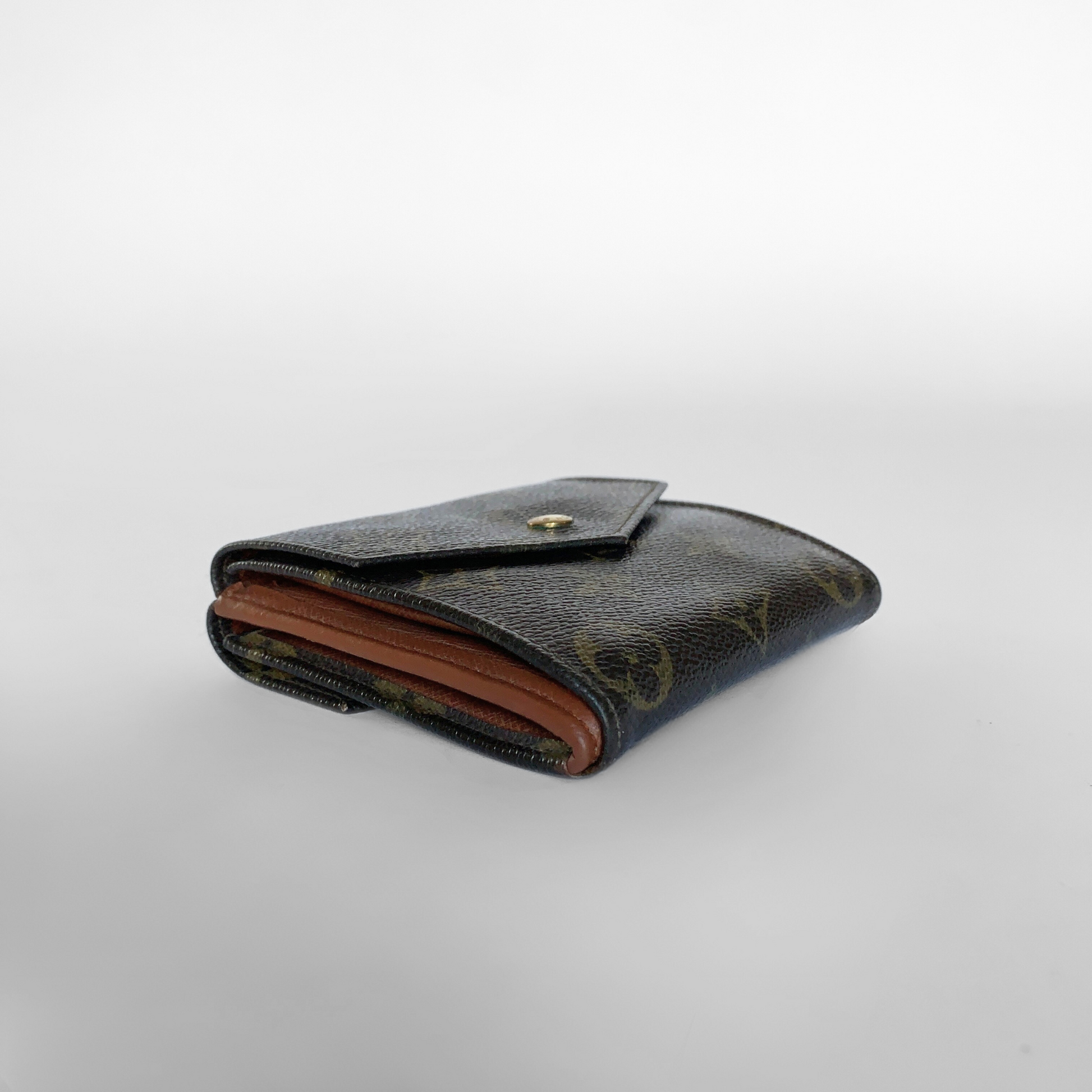 Louis Vuitton wallet with monogram pattern on a light gray background