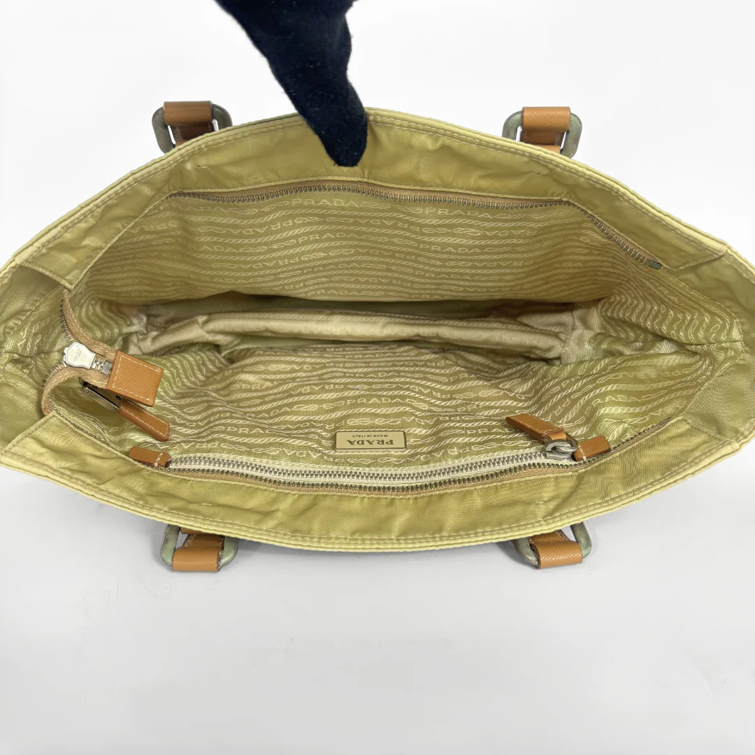 Prada yellow nylon tote bag with tan leather handles and triangle logo.