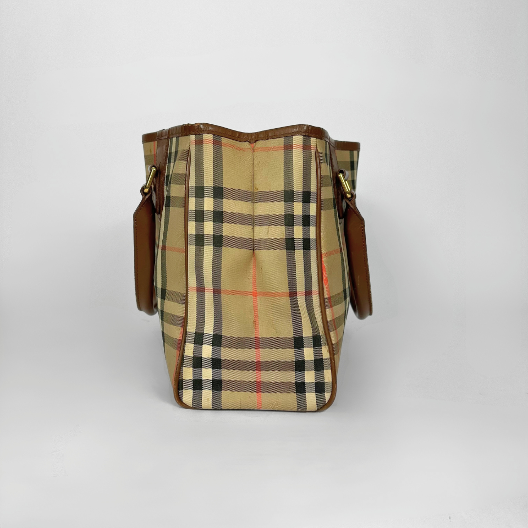 Plaid patterned bag with brown leather straps on a white background