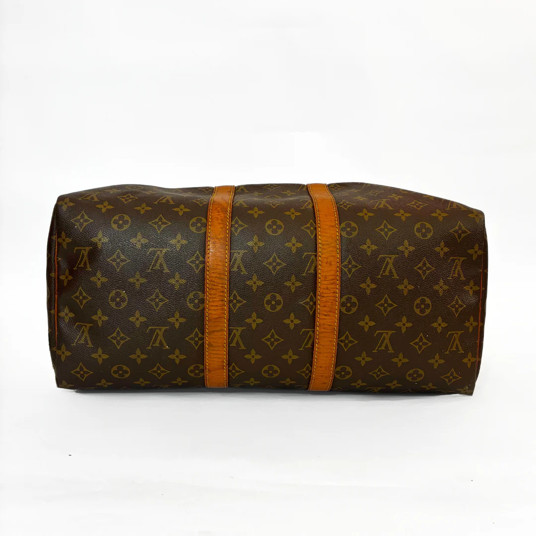 Brown monogram patterned bag with orange straps on a white background