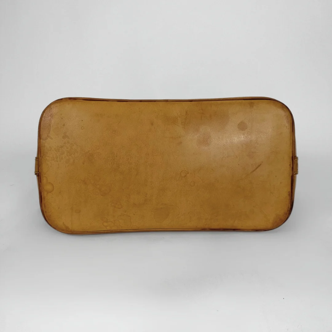 A vintage tan leather cosmetic pouch or case with rounded corners and a zippered closure, shown against a plain light gray background.