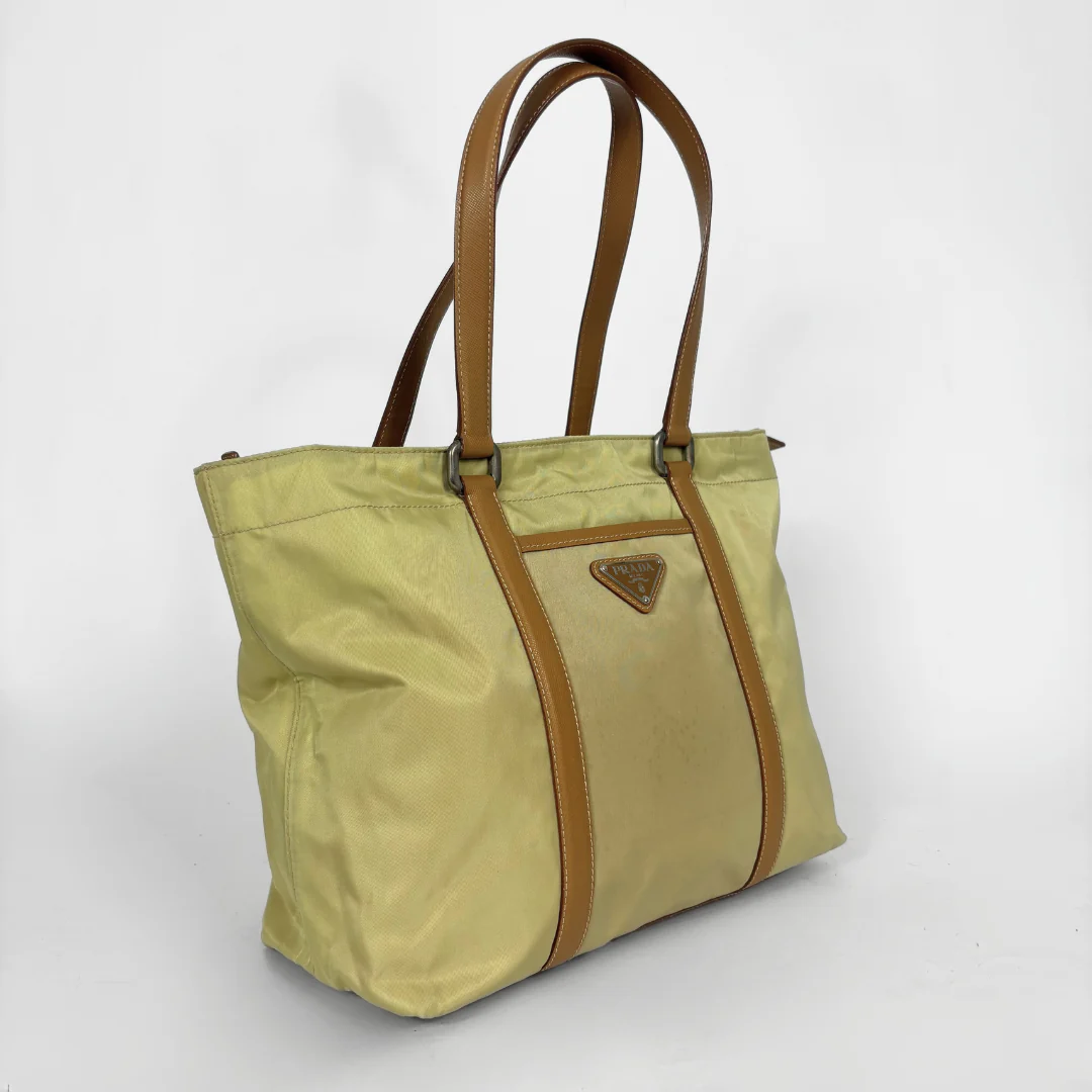 Prada yellow nylon tote bag with tan leather handles and triangle logo.