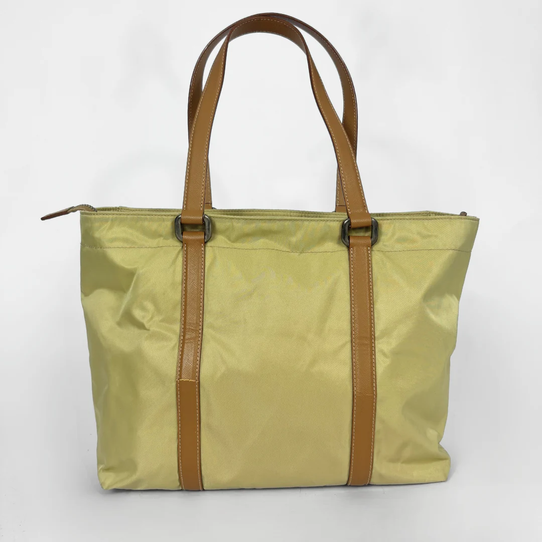 Prada yellow nylon tote bag with tan leather handles and triangle logo.