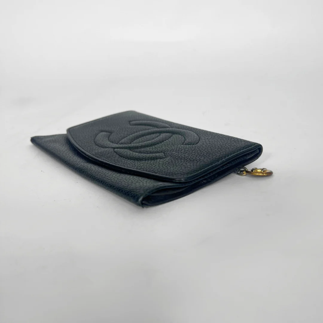 Black wallet with gold zipper on a light gray background