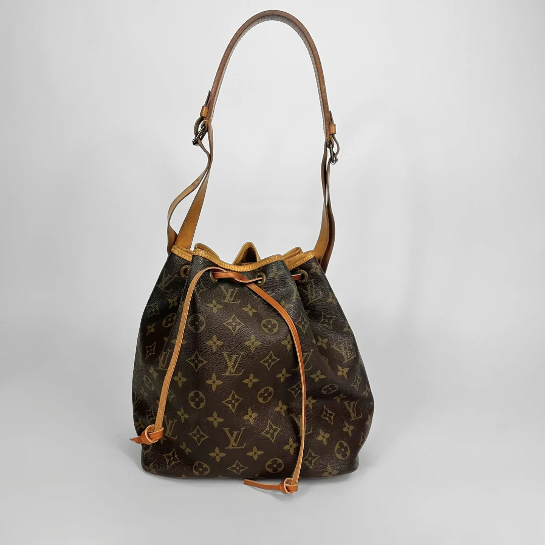 Brown monogram handbag with tan leather straps on a white background