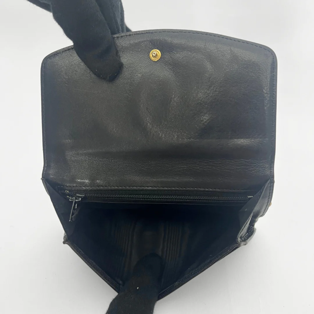 Black leather bag with a gold clasp on a white background