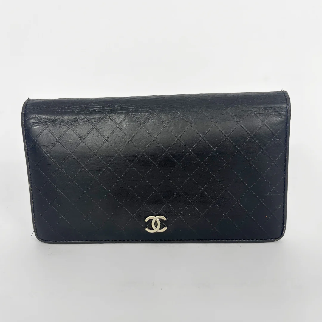 Black quilted wallet with Chanel logo on a white background