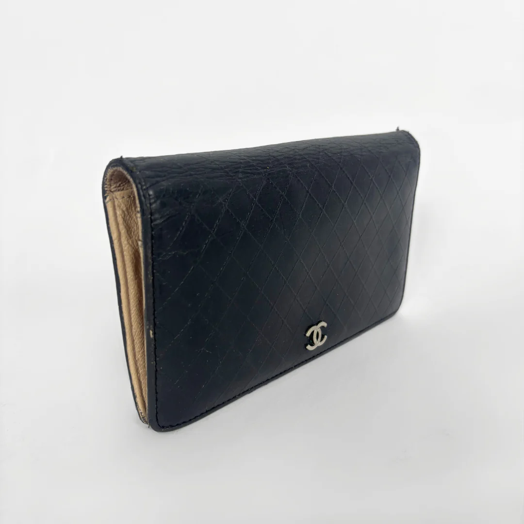 Black quilted wallet with Chanel logo on a white background