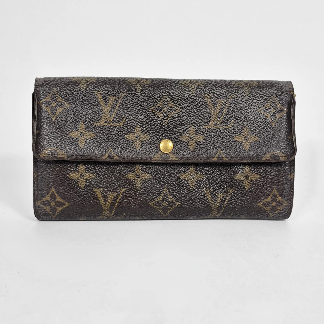 Louis Vuitton wallet with monogram pattern on a light gray background