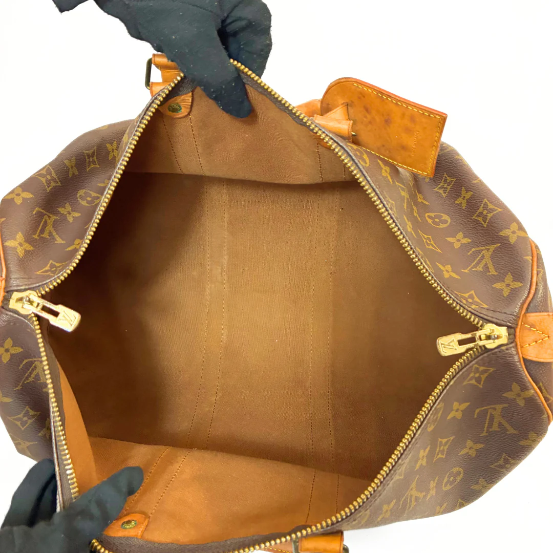 Brown monogram patterned bag with orange straps on a white background