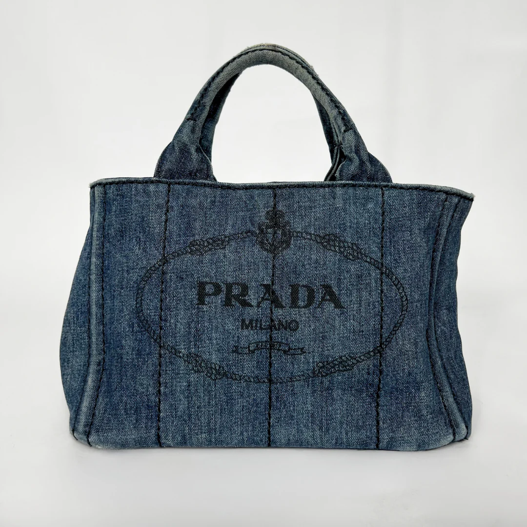 Blue denim handbag with Prada logo on a white background