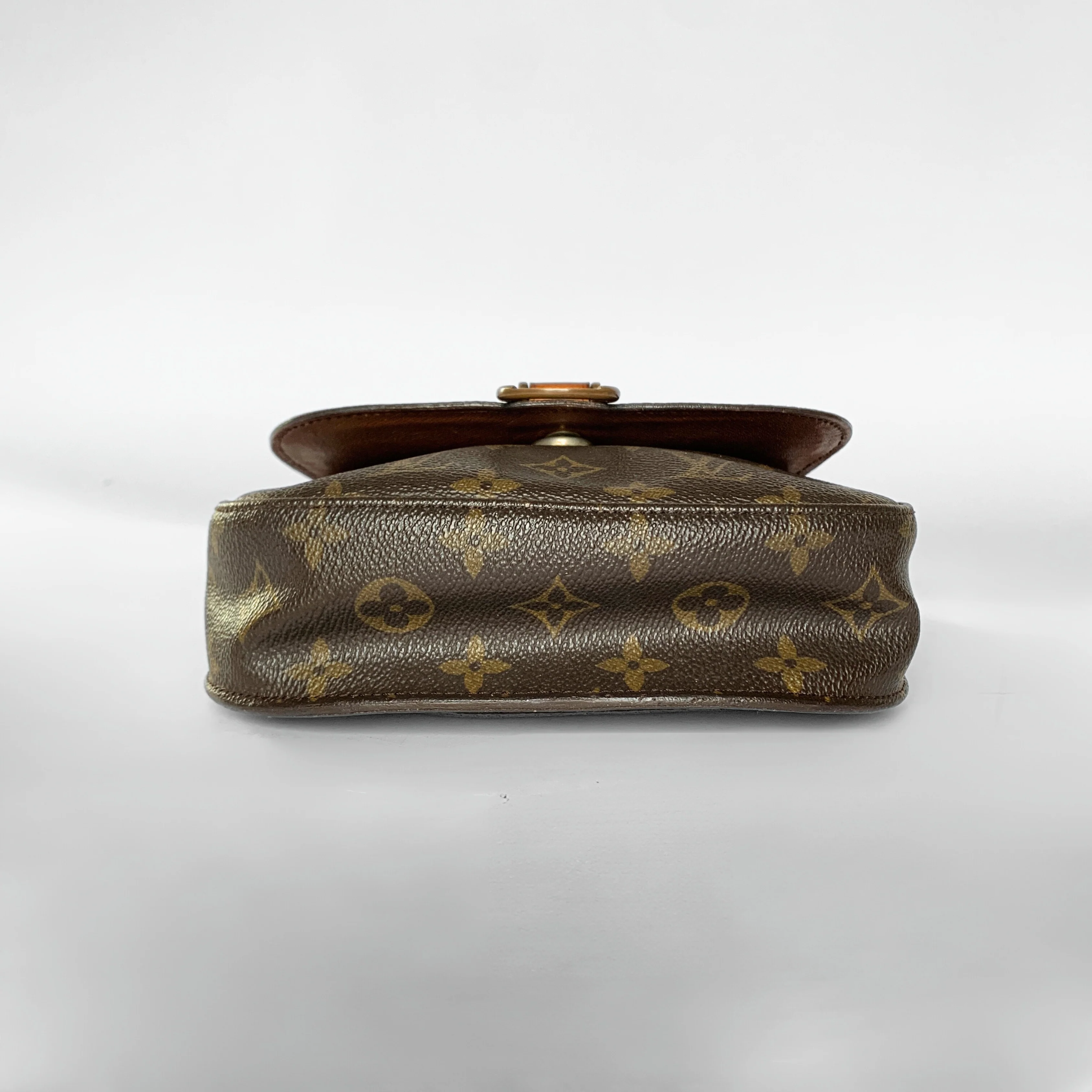 Brown leather handbag with gold monogram pattern on a white background
