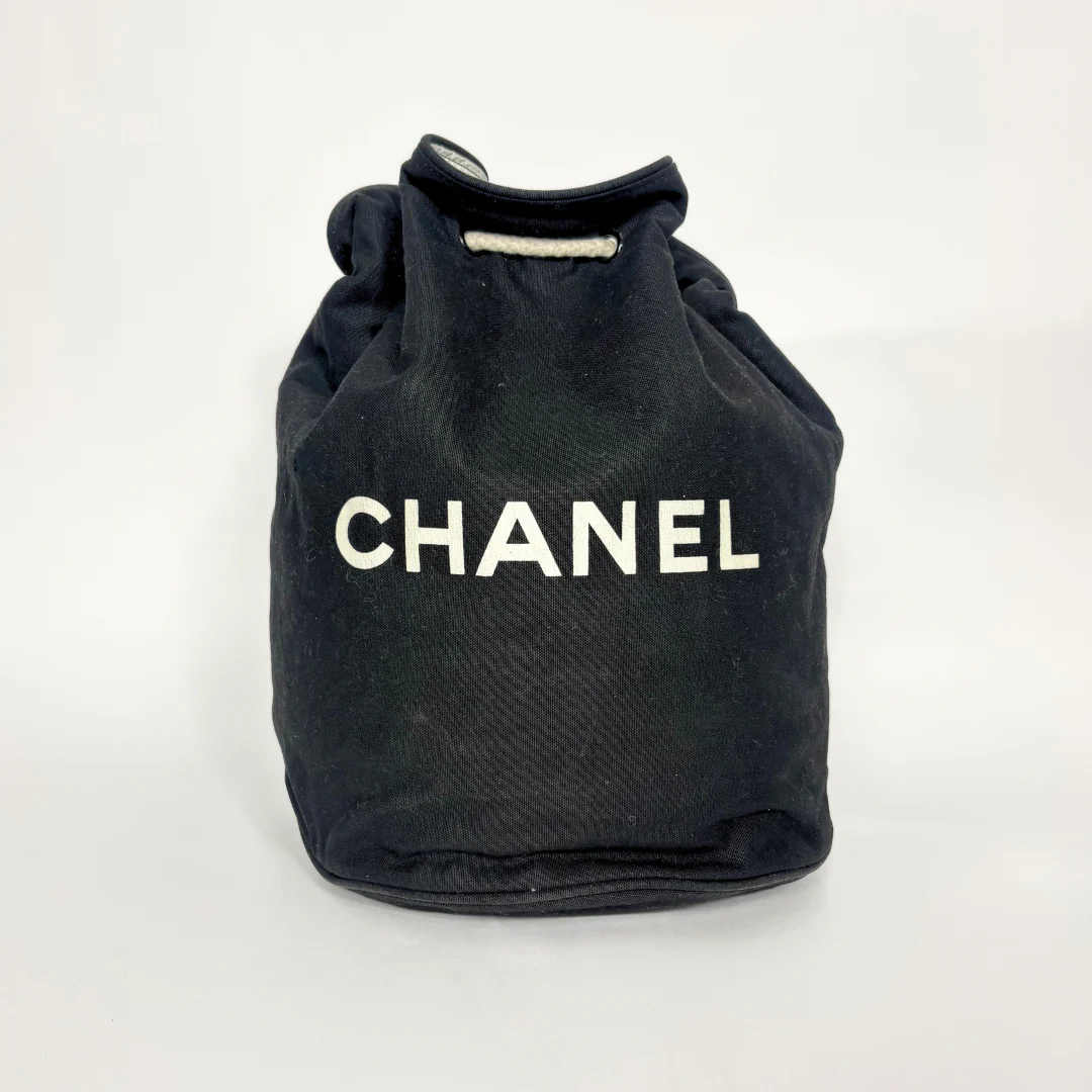 Black drawstring bag with 'Chanel' branding on a white background
