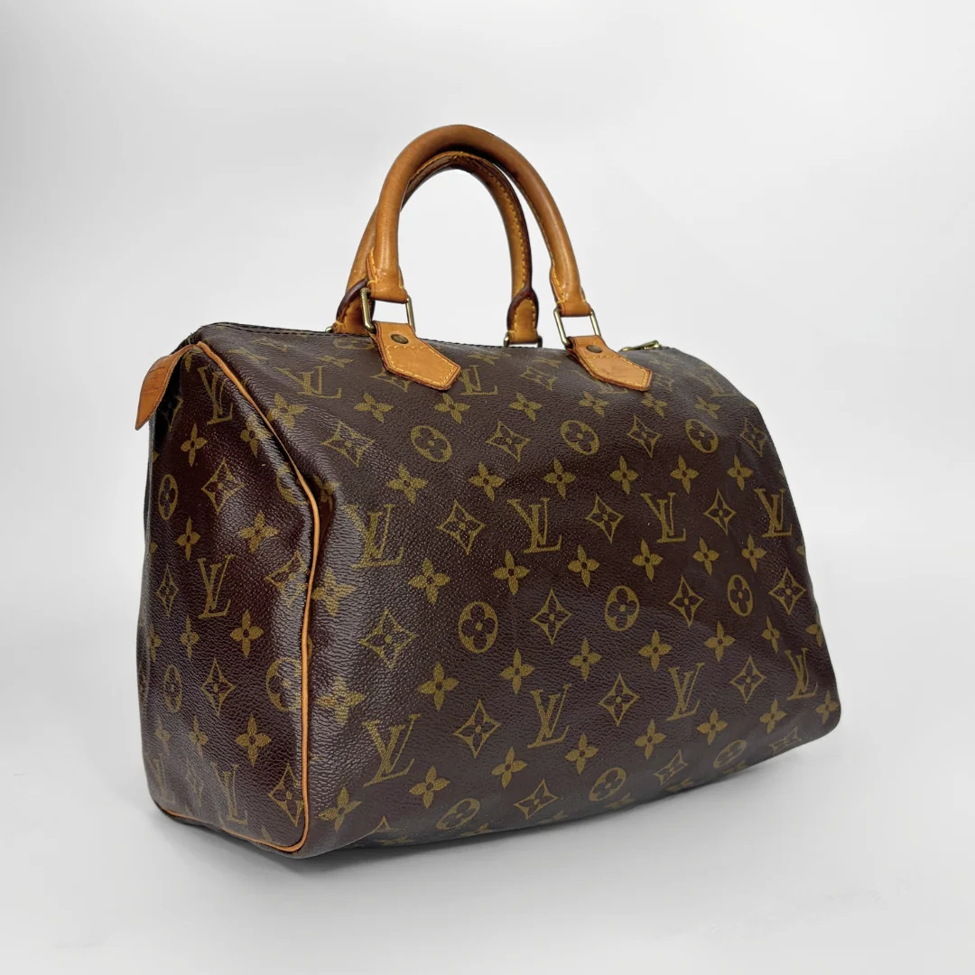 A Louis Vuitton monogram canvas duffel bag with tan leather handles and trim, photographed on a light gray studio background.