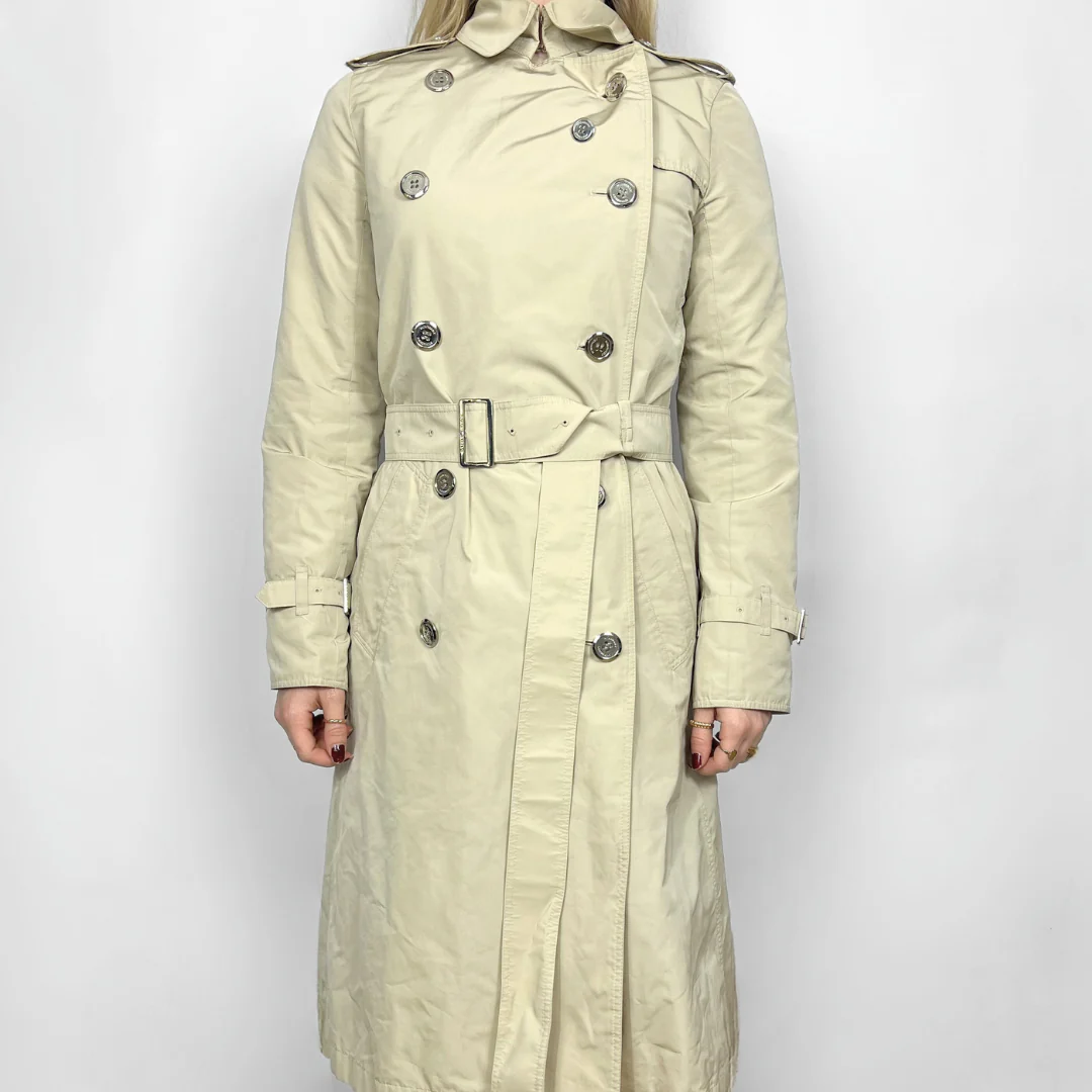 Beige trench coat worn by a person on a white background