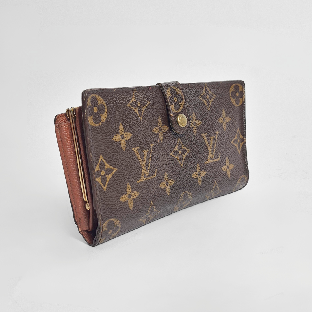 Louis Vuitton wallet with monogram pattern on a light gray background