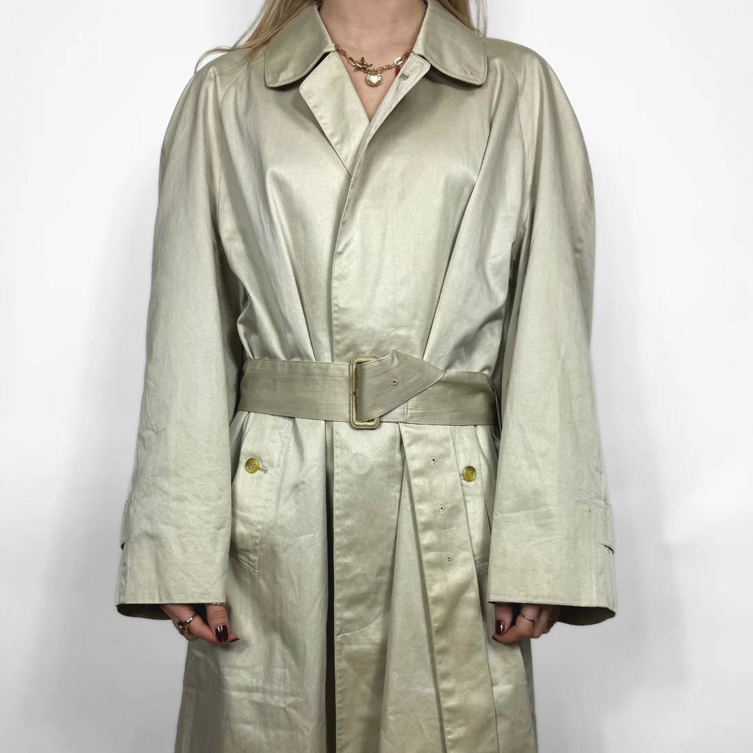 Beige trench coat worn by a person on a white background