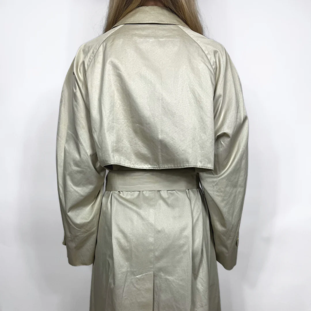Beige trench coat worn by a person on a white background