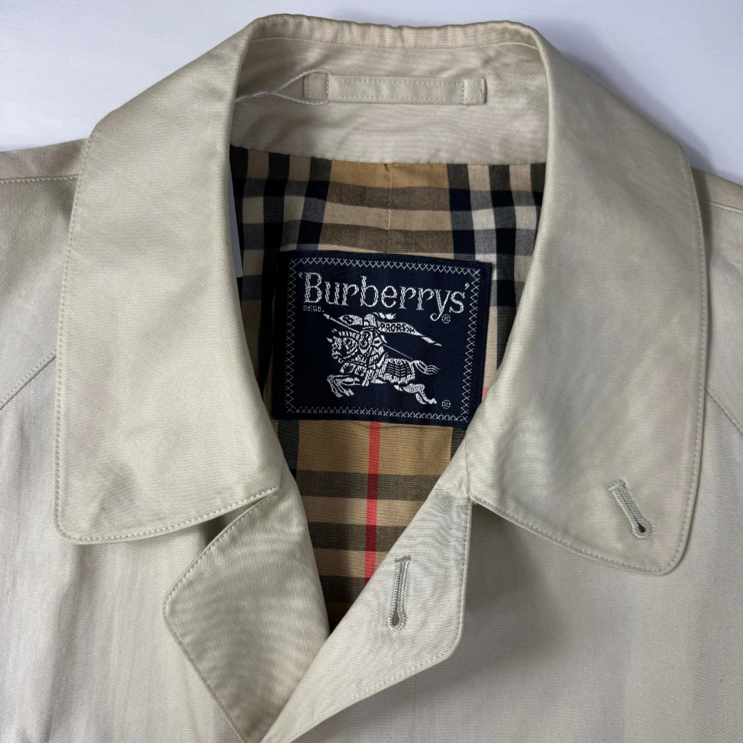 Beige Burberry jacket with brand label on a light gray background