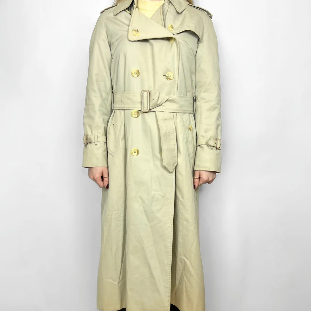 Beige trench coat with gold buttons on a white background