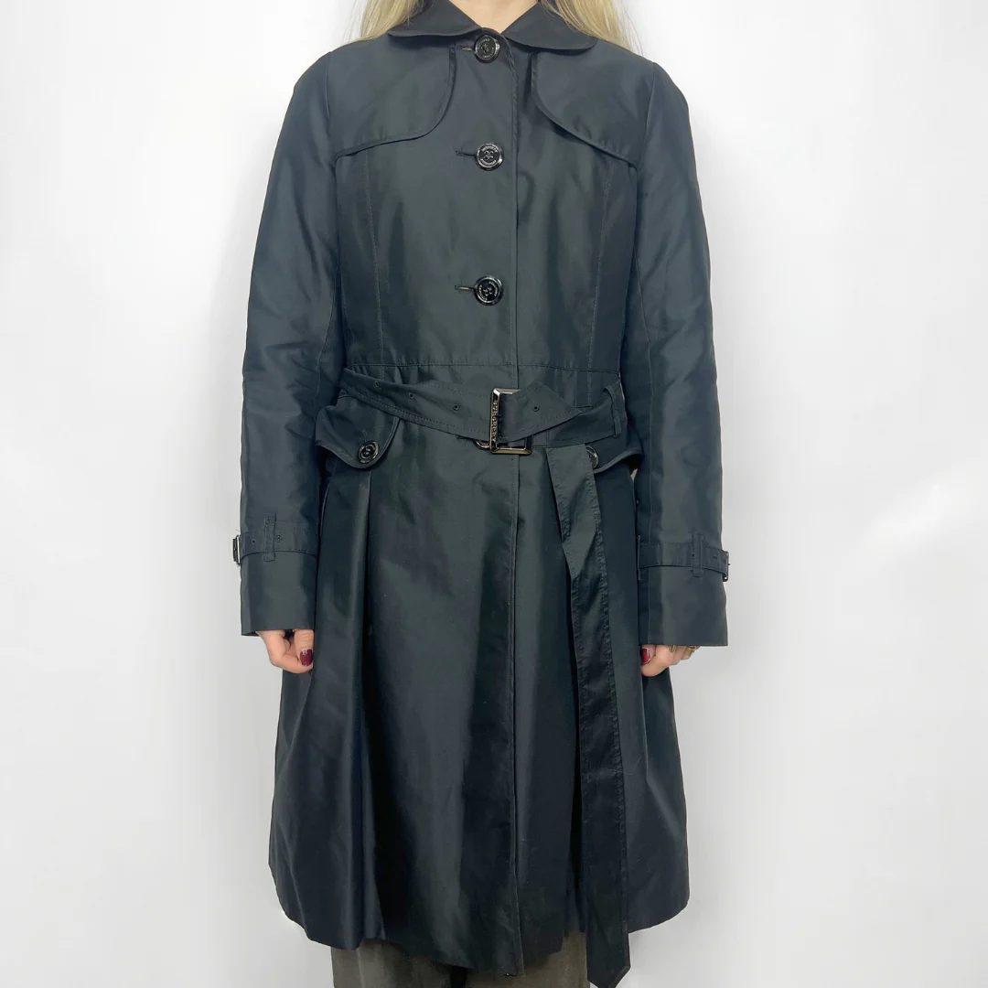 Dark gray trench coat worn by a person on a white background