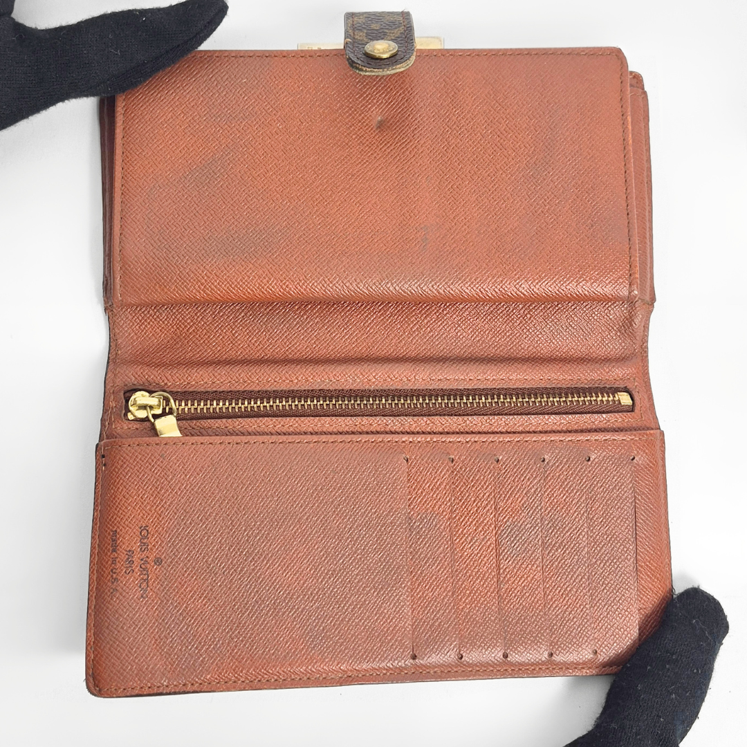 Brown leather wallet with gold zipper on a white background